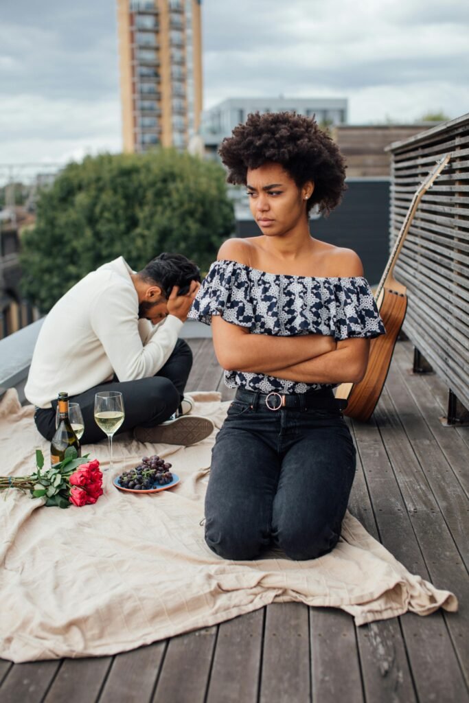 Home A couple on a rooftop picnic, with tension visible between them.